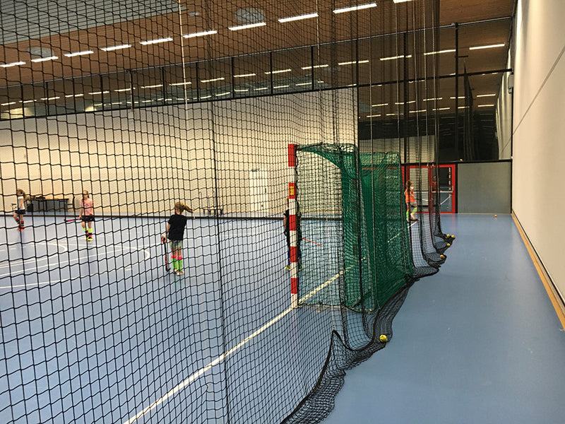 zaalhockey doel met groen doelnet en een zwart afscheidingsnet